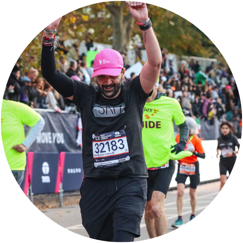 Sam mid-race at the NYC Marathon, arms up